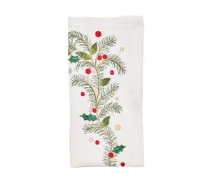 The Christmas Carol Table Linen Collection by Kim Seybert features a white embroidered linen napkin adorned with green pine branches, holly leaves, and red and gold berries—ideal for festive holiday table settings.