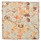 The Giverny Napkin Set by Kim Seybert features square napkins with an ornate, abstract floral pattern in orange, brown, and beige on a light background, inspired by Monet’s impressionist style.
