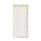 The Lune Napkin Set by Kim Seybert features white embroidered napkins with scalloped edges and gold detailing, ideal for adding elegance to your table setting.