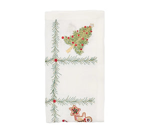Kim Seybert Christmas Trellis Napkin in white linen with an embroidered green pine pattern featuring a Christmas tree, a gingerbread man, and a star.