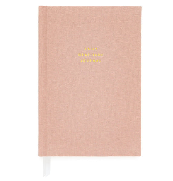 The Sugar Paper Gratitude Journal in Rose, created by Sugar Paper, is a closed pink hardcover book with gold embossed text and includes a white ribbon bookmark, making it ideal for your daily check-in of appreciation.