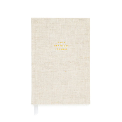 The Flax Gratitude Journal by Sugar Paper is a beige linen-covered journal with elegant gold “Daily Gratitude Journal” text, featuring thoughtful prompts and a white ribbon bookmark to guide your daily reflections.