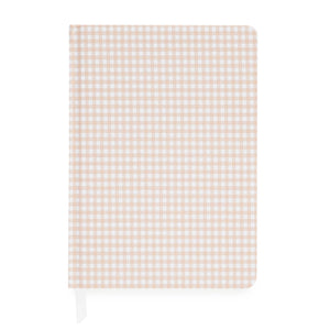 The Pink Gingham Tailored Journal by Sugar Paper features a charming beige and white gingham check cover. Shown closed with a white ribbon bookmark peeking out from the bottom left, this journal offers a durable book cloth hardcover and lined pages for organized note-taking.