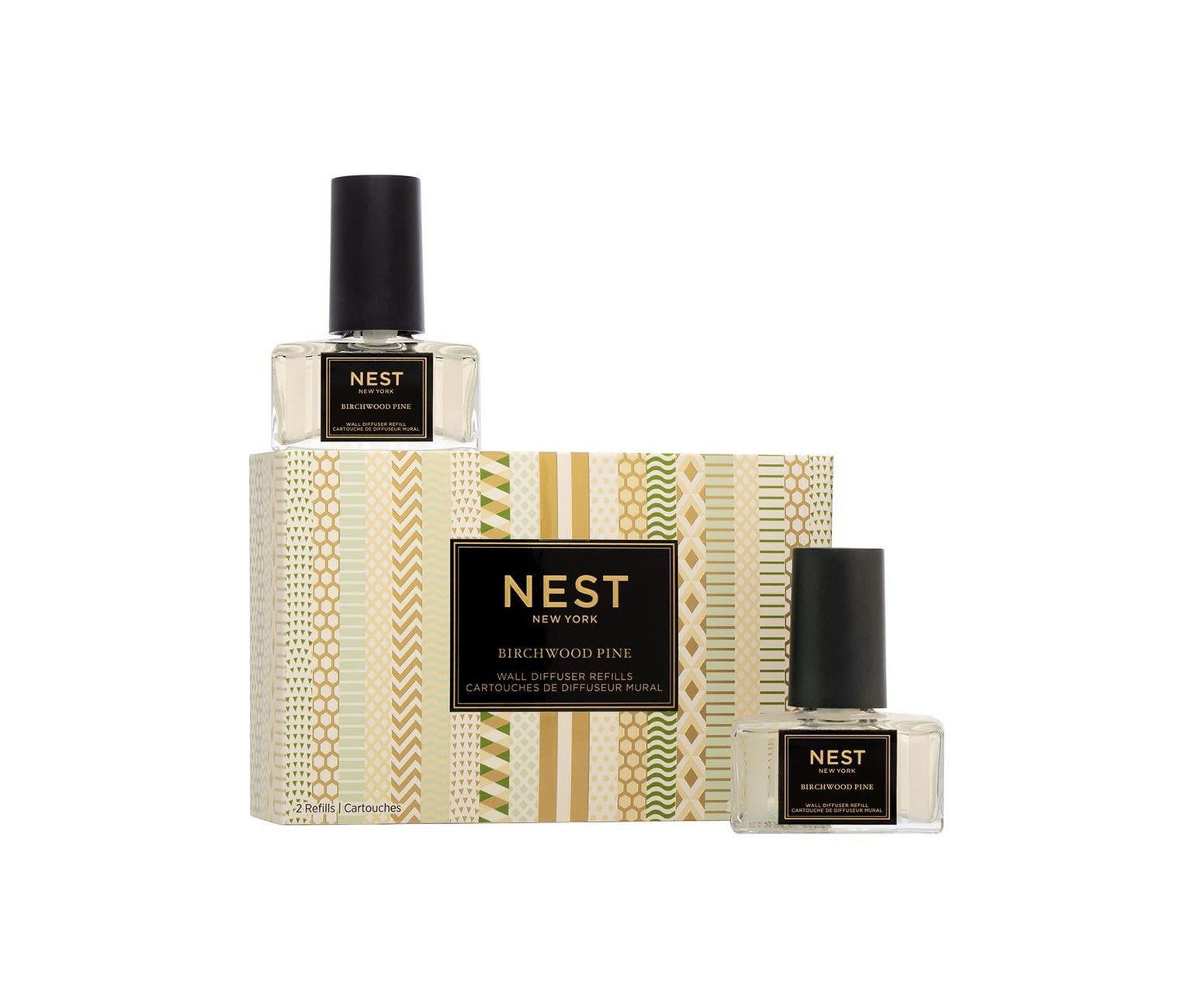 Two bottles from the Nest Birchwood Pine Collection wall diffuser refills are displayed next to their patterned box, capturing a winter forest scent, all set against a clean white background.