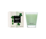 Nest's Cucumber & White Sage Scent Collection candle features a refreshing wellness fragrance and is pictured beside its white box decorated with green plant illustrations.