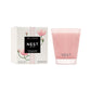 A pink Nest Himalayan Salt & Rosewater Candle from the Candle Collection sits by its floral box, exuding soothing rosewater and amber notes in an elegant presentation.