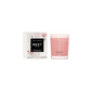A Nest Himalayan Salt & Rosewater Candle from the Candle Collection sits beside its white floral-accented box, infusing the air with a delicate rosewater and amber fragrance.