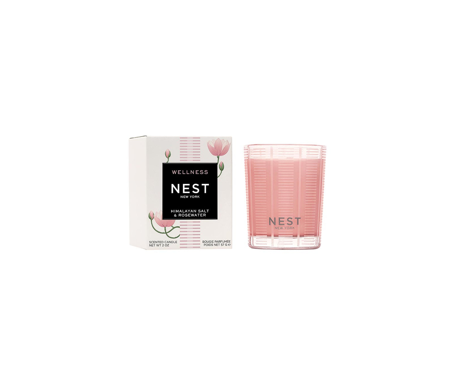 A Nest Himalayan Salt & Rosewater Candle from the Candle Collection sits beside its white floral-accented box, infusing the air with a delicate rosewater and amber fragrance.