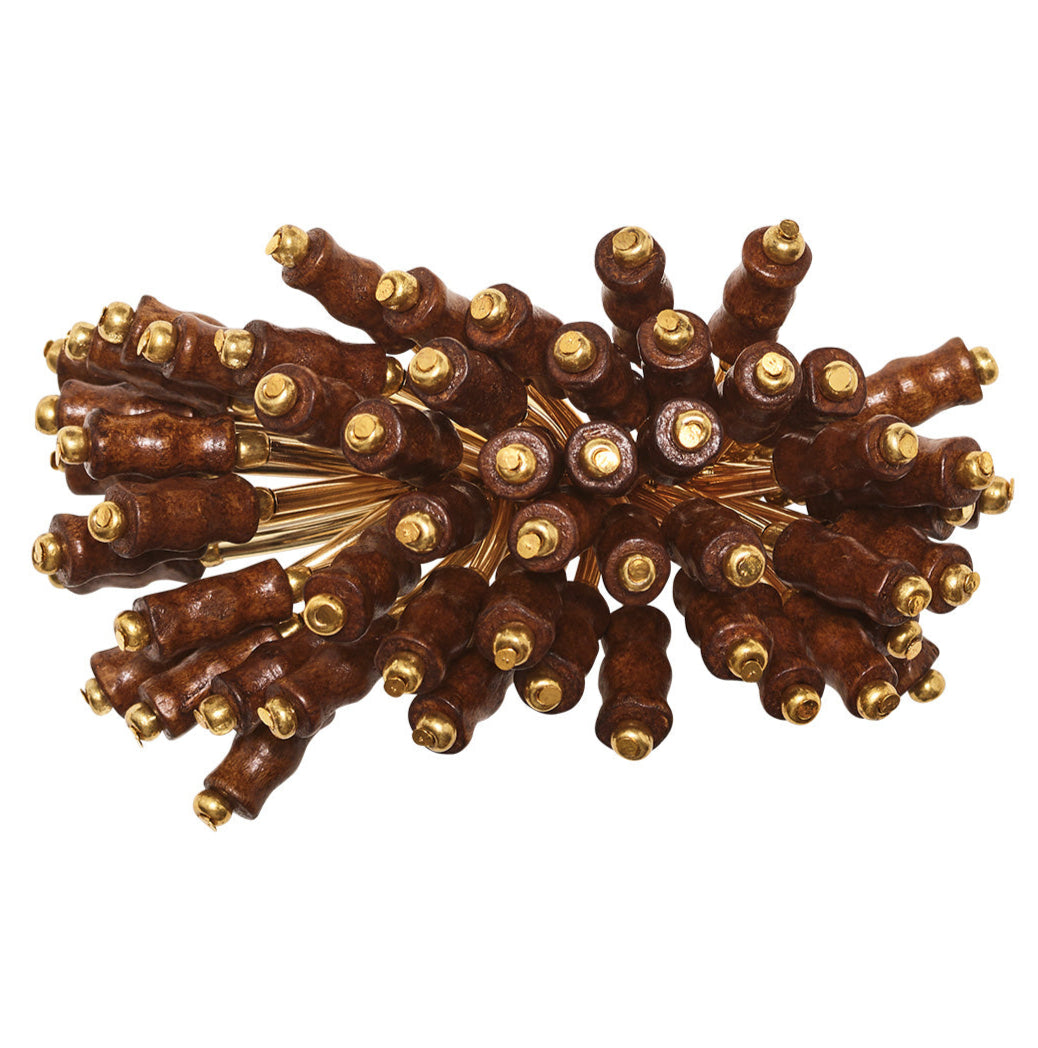 The Kim Seybert Royal Palm Napkin Ring features gold-tipped brown wooden sticks arranged radially, bringing subtle tropical flair to your table setting.