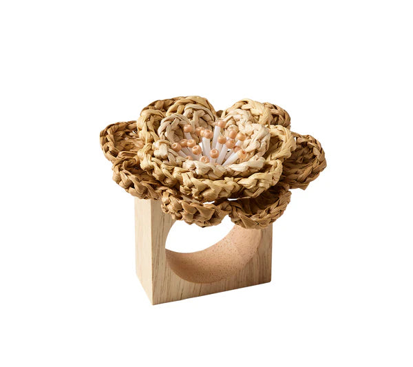 The Kim Seybert Pareo Napkin Ring features a rectangular wooden base topped with a woven raffia-style flower, accented by beige and white center details.