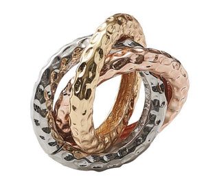 The Trinity Napkin Ring Set by Kim Seybert features three interlocking hand-hammered metal rings in silver, gold, and rose gold for an elegant, modern table accent.