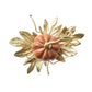 An orange Kim Seybert Gilded Gourd Napkin Ring resting on a cluster of gold metallic leaves.