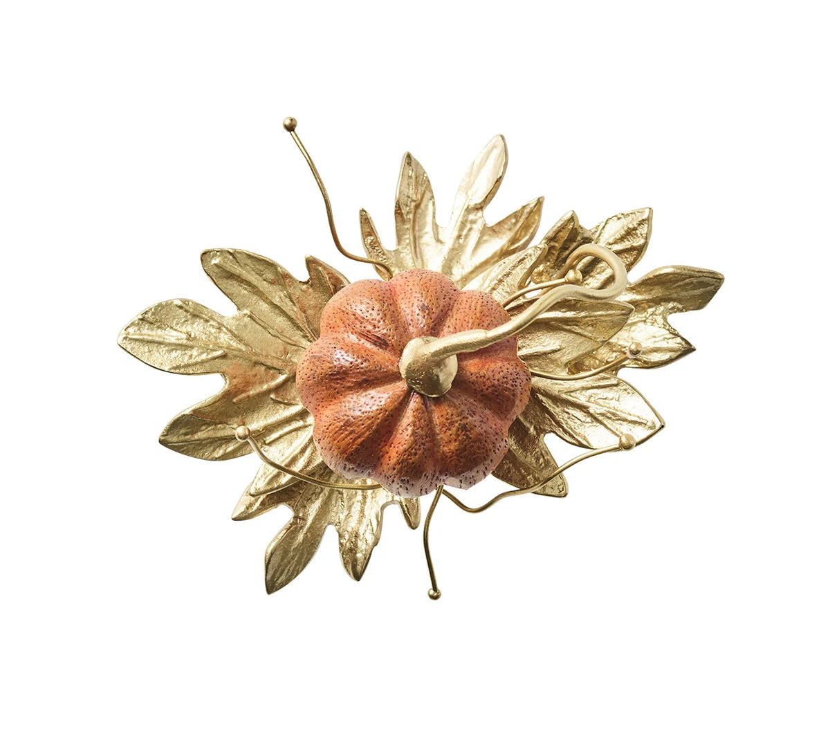 An orange Kim Seybert Gilded Gourd Napkin Ring resting on a cluster of gold metallic leaves.