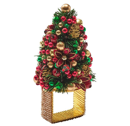 Kim Seybert Tinsel Tree napkin ring topped with a miniature Christmas tree decorated with red and green ornaments, gold bells, and pinecones for holiday dining.