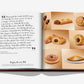 An open Assouline Nutella book shows a quote about Nutella’s history on the left page and assorted Nutella-filled pastries and cookies inspired by classic recipes on the right page.