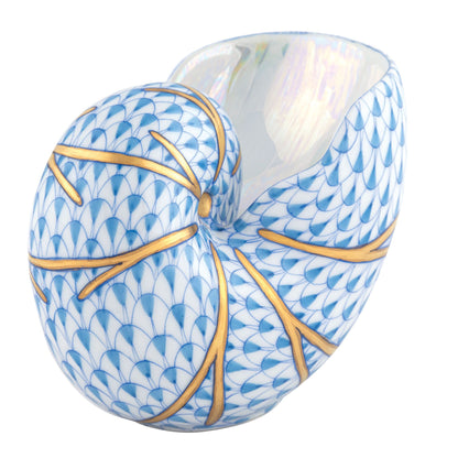 The Herend Small Nautilus Shell is a porcelain vase with hand-painted blue scale patterns and gold branch-like lines, plus a glossy, iridescent white interior.
