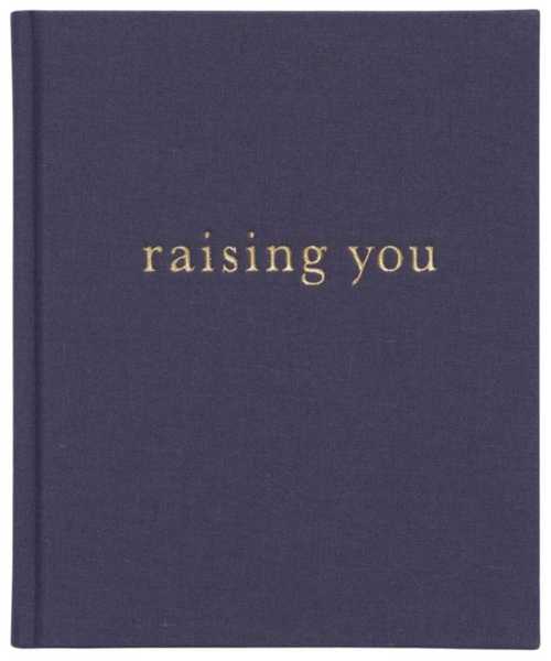 A navy blue linen hard cover book with the title "Write To Me Raising You Letters to my Baby Slate" embossed in gold lowercase letters.
