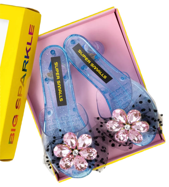 Packaged in a distinctive pink and yellow "Super Smalls" box, the Super Smalls Opening Night Play Shoes feature blue, kid-sized transparent design with dazzling sparkly blue kitten heels and pink flower jewels, making them an ideal addition to any dress-up collection.