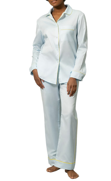 Woman wearing Matouk Nocturne Pajama Set with yellow piping, standing against a white background.