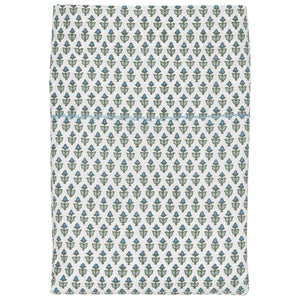 The Cala Sage Bedding Collection by John Robshaw features folded organic cotton fabric with a soft 400 thread count and a repeating pattern of small green and blue plant motifs on a white background.