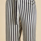 Close-up of Olivia von Halle's Lila Silk Pajamas featuring black and white vertical stripes with a waistband tie—shown from waist to mid-thigh, these elevate your classic pajama look.