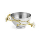 A silver bowl from Michael Aram’s Orchid Serveware Collection features gold and white floral branch handles on the sides and a textured interior, reflecting timeless allure and exquisite craftsmanship.