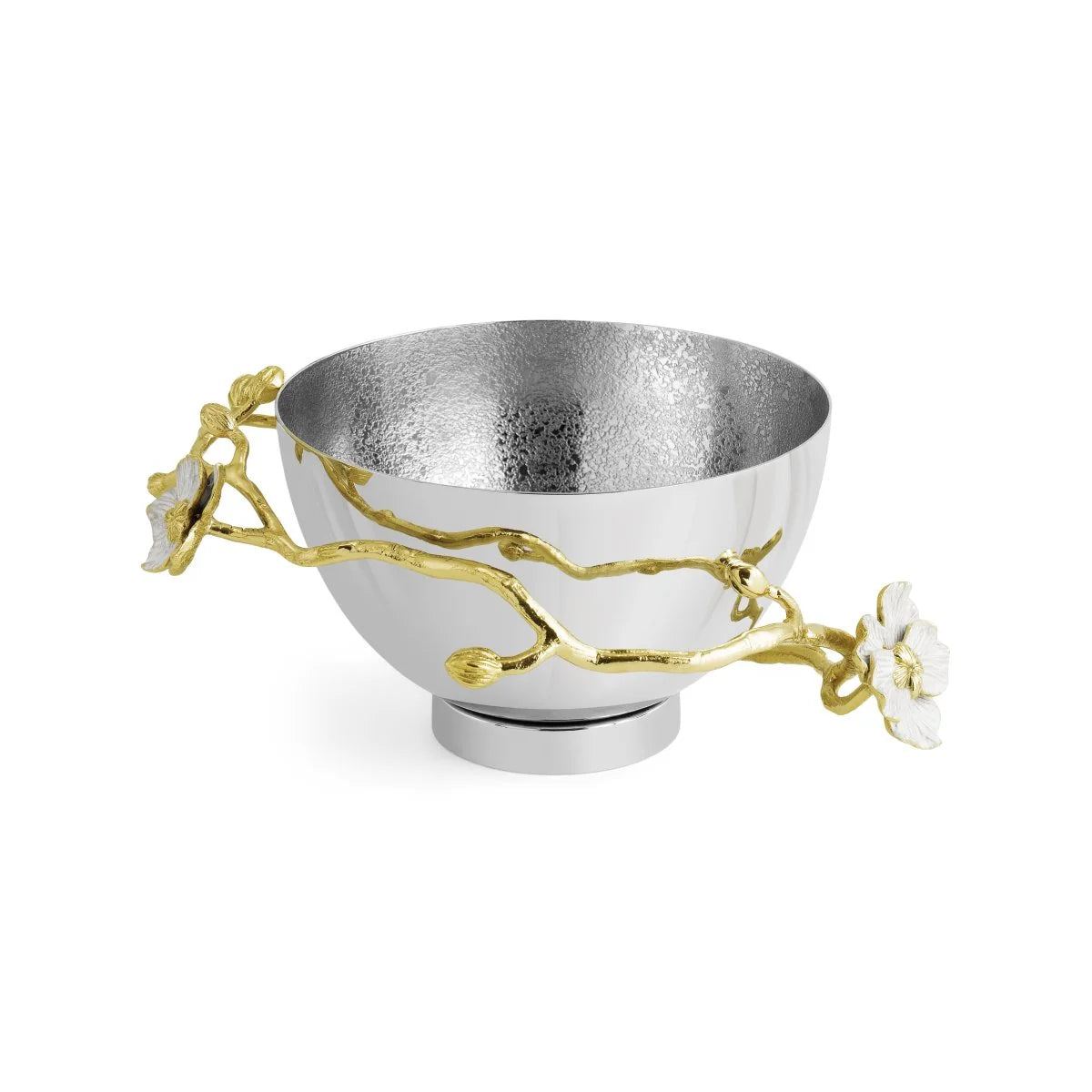 A silver bowl from Michael Aram’s Orchid Serveware Collection features gold and white floral branch handles on the sides and a textured interior, reflecting timeless allure and exquisite craftsmanship.