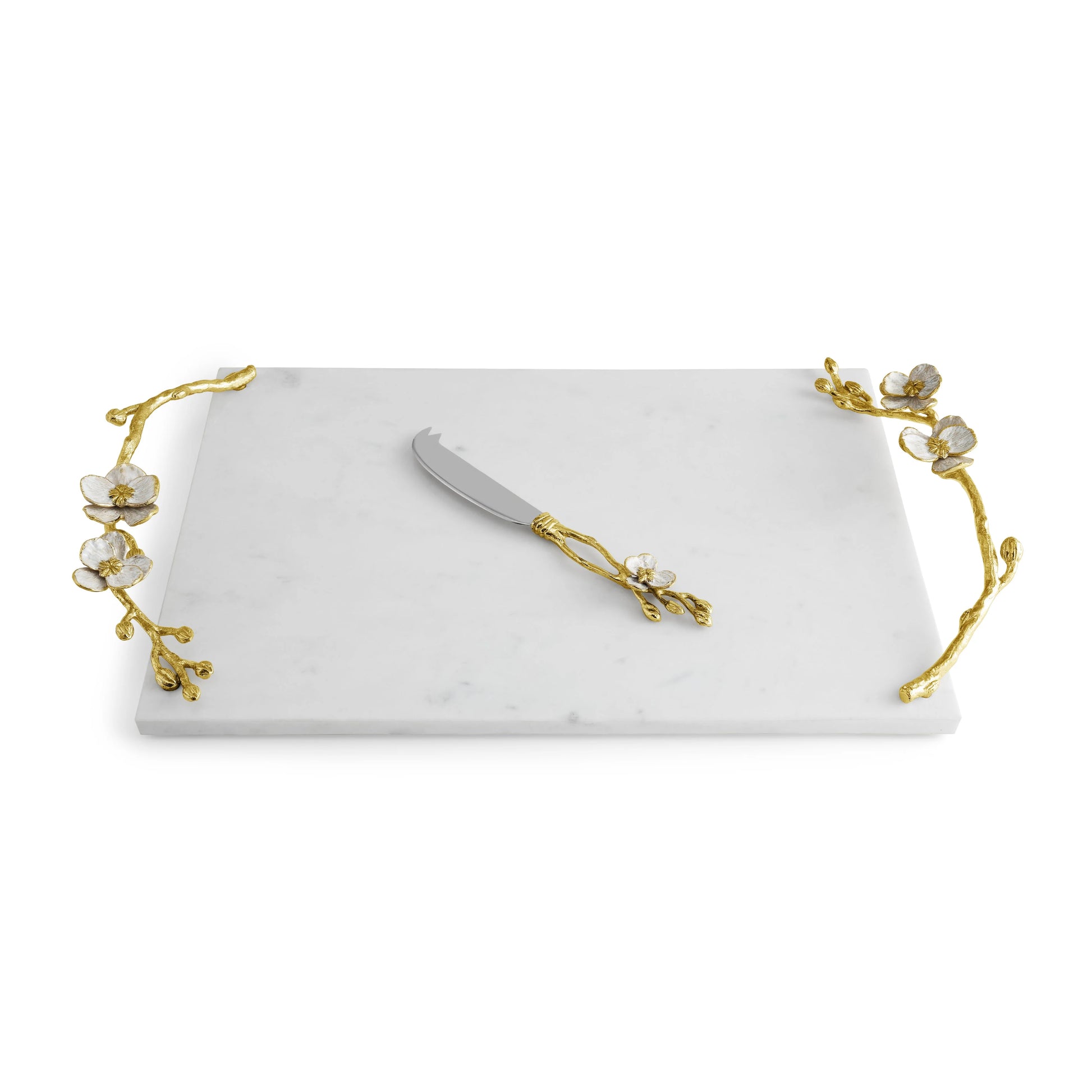 The Michael Aram Orchid Serveware Collection features a rectangular white marble serving tray with gold floral handles and a matching cheese knife, reflecting exquisite craftsmanship and timeless elegance.