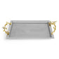 The Michael Aram Orchid Serveware Collection features a rectangular silver tray with gold-toned branch handles and white flower accents, combining elegance and exquisite craftsmanship for timeless gatherings.