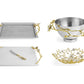 The Michael Aram Orchid Serveware Collection features four pieces—tray, bowl, cheese board with knife, and shallow dish—adorned with gold and white floral branches for elegant, timeless appeal.