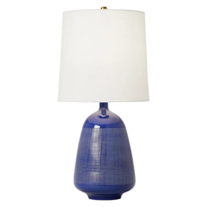 The Ornella Medium Table Lamp by Visual Comfort features a blue textured base inspired by 1950s Italian pottery and is topped with a white cylindrical shade, blending vintage charm and modern elegance.