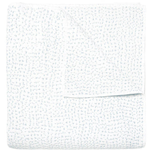 The Stitched Mist Coverlet by John Robshaw is a folded white organic cotton voile blanket with a subtle grid texture and faint blue stitching, displayed on a plain white background.