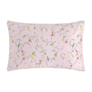 The Gooselings Dreaming of Paradise Bedding Collection features a rectangular children's pillow with a pale pink background, decorated with birds, branches, and pink and yellow flowers—perfect for sweet bedtime dreams.