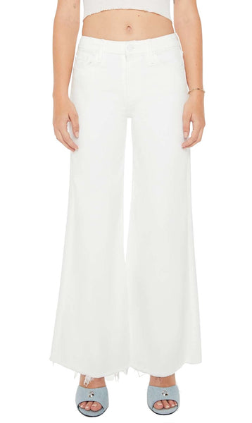 Woman wearing Mother Denim Lil Roller Fray Petite high-waisted wide leg white flared pants and silver sandals.