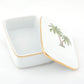 The Herend Palm Tree Decor Collection features a rectangular white porcelain box with a gold rim, hinged lid, and hand-painted palm tree illustration, shown partially open on a white background.
