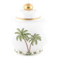 Herend's Palm Tree Decor Collection features a white ceramic jar with gold knob and rim, adorned with hand-painted green palm trees and plants—an elegant accent for any space.