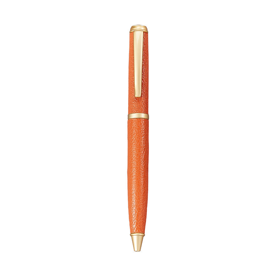 The Leather Wrapped Pen Collection by Graphic Image features an orange textured leather ballpoint pen with gold accents and a clip—a stylish gift for any writer, pictured against a white background.