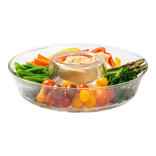 A Juliska Puro Glass Serveware Collection tray holds assorted fresh vegetables—carrots, green beans, tomatoes, and broccoli—artfully arranged around a central bowl of hummus. Subtle textured lines lend elegance to the mouth-blown glass.