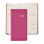 A 2027 Pocket Datebook by Graphic Image in pink rests atop an open weekly planner showing dates from July 12 to July 18, creating a delightful ensemble with a personal pocket journal perfect for organizing your schedule.