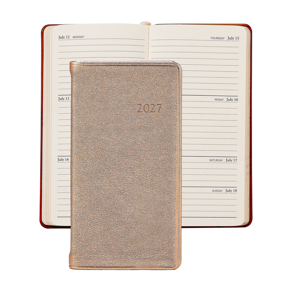 A Graphic Image 2027 Pocket Datebook with a metallic cover is placed on top of an open weekly planner showing dates from July 12 to July 18.