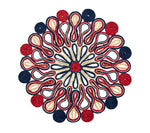 Symmetrical mandala pattern of coiled string in red, blue, and beige evokes the artisanal style of the Kim Seybert Marisol Placemat Collection, displayed on a crisp white background.
