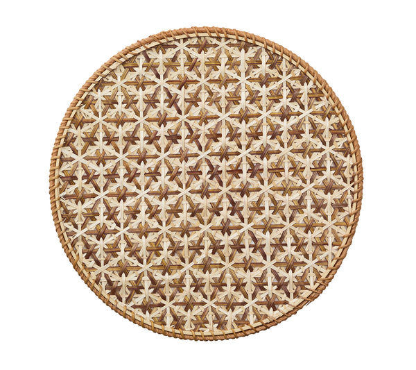 The Kim Seybert Lanai Placemat Collection features round, woven cane placemats with an intricate honeycomb design in natural brown and beige, shown on a white background.
