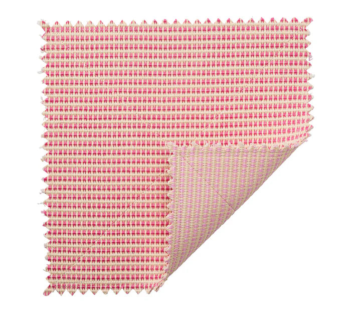 The Kim Seybert Duet Placemat showcases a red and white woven pattern with a folded corner, highlighting its reversible design for a chic table setting.