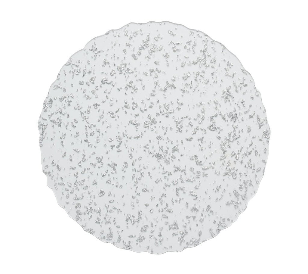 The Kim Seybert Stardust Placemat Collection features round, transparent placemats with scalloped edges and silver speckles, adding handcrafted elegance to any table setting.