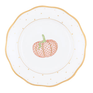 The Herend Fall Dessert Plate features white porcelain adorned with a gold rim and playful polka dots, showcasing an orange patterned pumpkin illustration at its center—making it a charming addition to your harvest season gatherings.