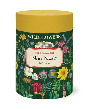 The Cavallini Papers and Co Mini 240 Piece Puzzles come in a cylindrical box with vibrant wildflower illustrations on a dark green background—an ideal gift or relaxing activity for nature lovers.
