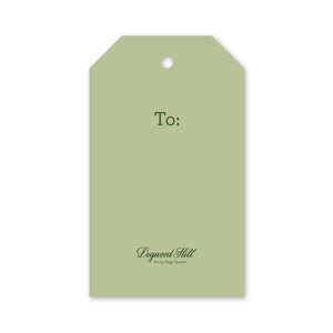 Sage green rectangular Merry Main Street Gift Tag with angled top corners, a hole for string, and the word “To:” printed in dark green.