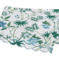 The Matouk Palmyra Bedding Collection, Emerald, features a folded tablecloth with green and blue palm fronds and leafy patterns on a white background, finished with a scalloped edge.