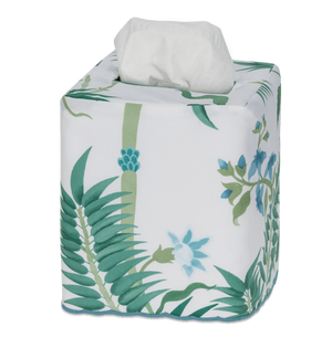 The Matouk Palmyra Tissue Box Cover in Emerald features a green leaf and blue flower pattern, bringing an island-inspired touch to your decor as it neatly covers a square tissue box with a white tissue popping out from the top.
