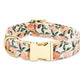 The Fabric Dog Collar Collection by Foggy Dog features a luxe peach and green leaf pattern with a gold metal buckle and D-ring—offering style and comfort for your pet.